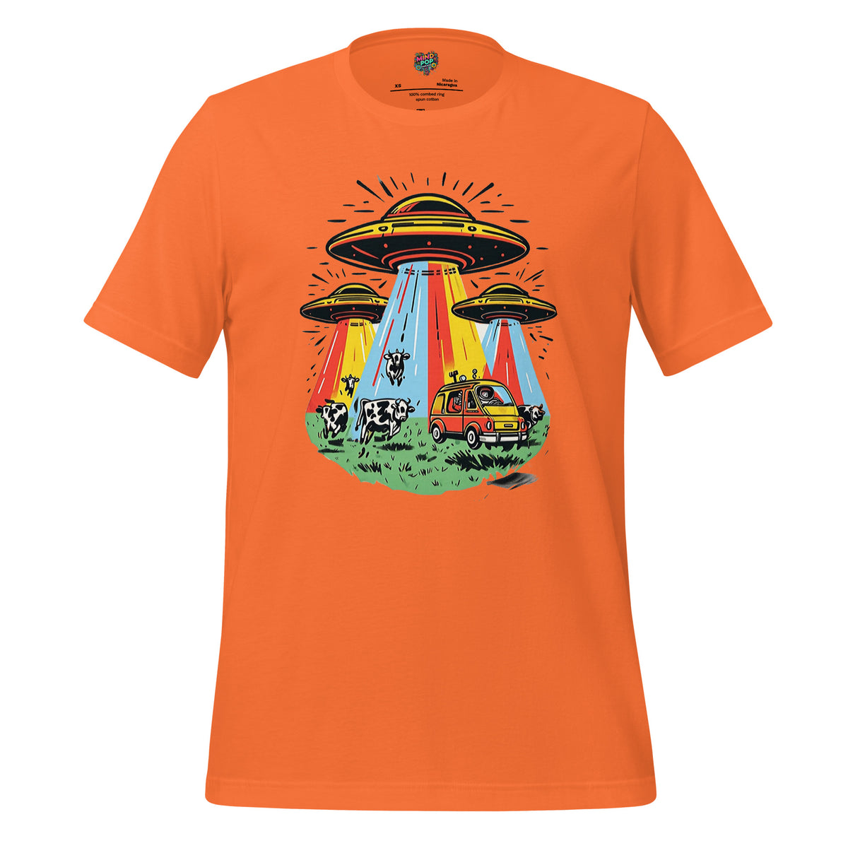 An orange short-sleeve crewneck t-shirt featuring a colorful retro graphic of three UFOs with rainbow beams, a yellow car, and cows on a grassy field, displayed against a solid white background.