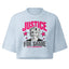 A light blue cropped t-shirt featuring a graphic print with the text 'JUSTICE FOR SHANE' in pink and black, flanking a portrait of a woman and pink stars.